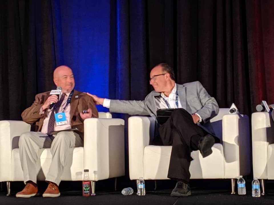 Bill Wagner and Brent Harris on stage together at a CoSIDA convention.